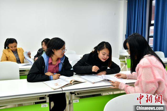 近日，从菲律宾来到福建师范大学海外教育学院求学的乔乐琳(右二)和林雅恩(右三)一同学习。　中新网记者 吕明 摄